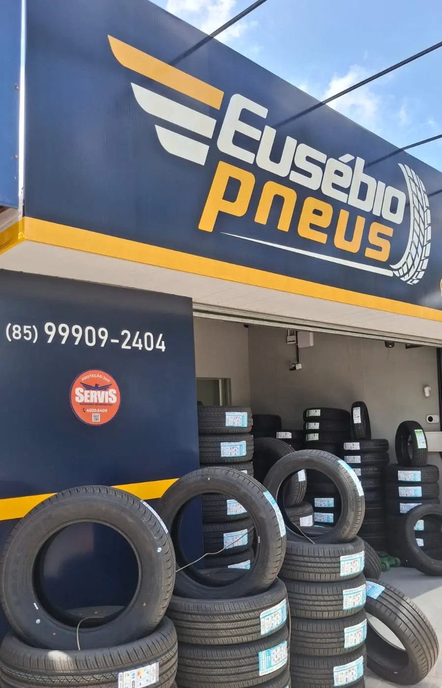 Fachada da Eusébio Pneus com pneus novos empilhados na entrada